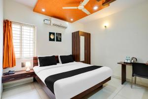 a bedroom with a bed and a desk and a window at Collection O Bangalore Airport Road in Bangalore