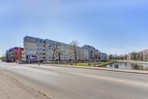 an empty street with a building and a river at Cozy Amber in Gdańsk