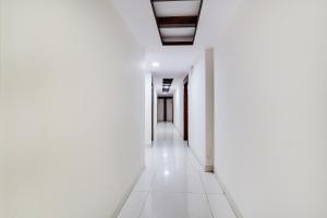 an empty corridor in an office building with white walls at Collection O Bangalore Airport Road in Bangalore