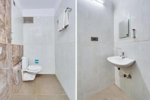 a white bathroom with a toilet and a sink at Collection O Bangalore Airport Road in Bangalore