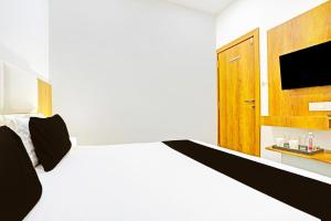 a bedroom with a bed with a tv and a door at Super Collection O Adajan Formerly Hotel Western Inn in Surat