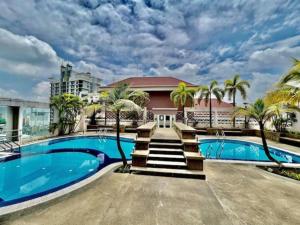 a swimming pool with palm trees and a building at Casa Mutiara Condo Bukit Bintang KLCC Kuala Lumpur by Travelardor in Kuala Lumpur