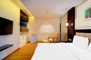 a hotel room with a bed and a kitchen at Palette South Delhi Formerly Imperial Villa in New Delhi