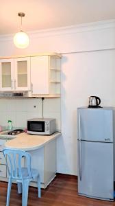 a kitchen with a refrigerator and a table with a blue stool at Casa Mutiara Condo Bukit Bintang KLCC Kuala Lumpur by Travelardor in Kuala Lumpur