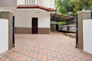 a building with a brick driveway in front of a door at Hotel O West Hill near Mietra Hospital in Calicut