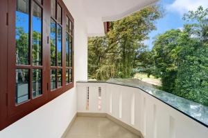 a balcony with a large window and a staircase at Hotel O West Hill near Mietra Hospital in Calicut +38 photos