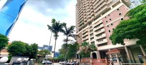 a city street with palm trees and a tall building at Casa Mutiara Condo Bukit Bintang KLCC Kuala Lumpur by Travelardor in Kuala Lumpur