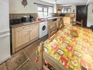 a kitchen with a table with a patterned table cloth at Cider House in Hawkchurch