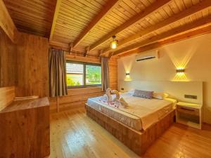 a bedroom with a bed in a room with wooden walls at Kaş Konak Bungalows in Kaş