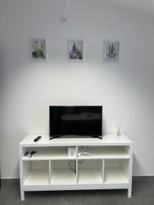 een wit entertainmentcentrum met een flatscreen-tv erop bij L&C hideaway in Sestu