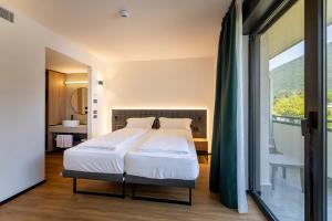 a bedroom with a bed and a large window at My Active Hotel in Levico Terme +79 photos