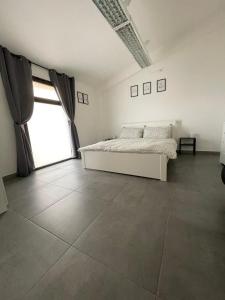 een slaapkamer met een bed en een groot raam bij L&C hideaway in Sestu