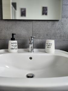 a bathroom sink with two cups on top of it at L&C hideaway in Sestu