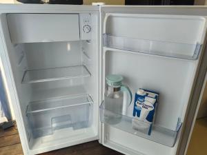 an open refrigerator with a bottle of milk and a jug of water at Lofdal Guesthouse in Kimberley