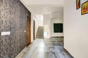 a hallway with a tile floor and a staircase at Super Hotel O Porvorim in Goa