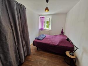 a bedroom with a purple bed and a window at Appartement tout confort à Begnécourt Vosges endroit calme idéal famille in Begnécourt
