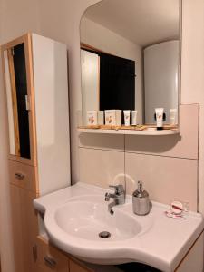 a bathroom with a white sink and a mirror at Appartement tout confort à Begnécourt Vosges endroit calme idéal famille in Begnécourt +13 photos