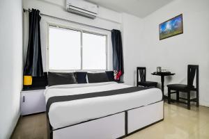 a bedroom with a large bed and a window at Super Hotel O Indraprasth in Indore