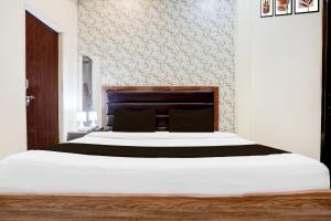 a bedroom with a large bed with white sheets at Super Hotel O Sankat Mochan Gandhi Nagar in Varanasi +33 photos