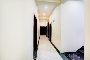 a corridor of a room with white walls at Super OYO Hotel O Sankat Mochan Gandhi Nagar in Kakarmatha