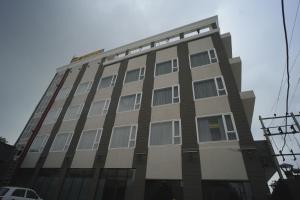 a tall building with windows on the side of it at Hotel Devaan in Kālānwāli