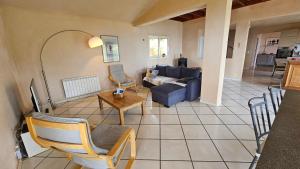 a living room with a blue couch and a table at Sari- Vue mer- climatisation in Sari Solenzara