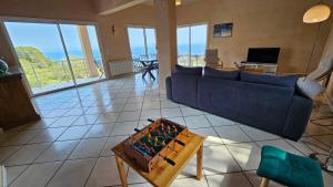 a living room with a blue couch and a table at Sari- Vue mer- climatisation in Sari Solenzara +12 photos