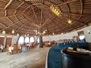 a large room with tables and chairs and a large ceiling at Ambokili Cottages in Kimana