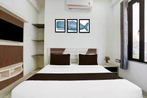 a bedroom with a large white bed and two windows at Super Townhouse Khatu Shyam Formerly Hotel Dev Bhumi in Khātu