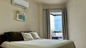 Una cama o camas en una habitación de Frente Mar Apartamento 3Q em Itapema, Meia Praia, suite e 2BWC, Ar Condicionado, Smart TV, garagem e churrasqueira na sacada