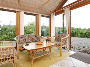 a screened in porch with a table and chairs at Seaside Panorama Escape - By Traum Ferienwohnungen in Otterup