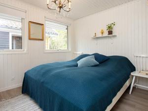 a bedroom with a blue bed and a window at 6 person holiday home in Karrebæksminde-By Traum in Karrebæksminde