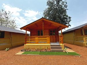a log cabin with a porch and stairs in front of it at DEER COTTAGES Agonda in Agonda