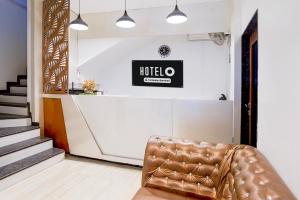 a leather chair in a lobby with a hotel sign on the wall at Super Hotel O Itwari Railway Station Formerly Hotel Prime in Nagpur
