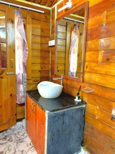 Baño de madera con lavabo y espejo en DEER COTTAGES Agonda, en Agonda