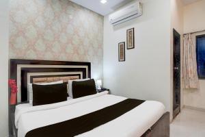 a bedroom with a large white bed in a room at Super Hotel O Itwari Railway Station Formerly Hotel Prime in Nagpur