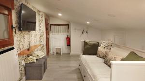 a living room with a white couch and a television at SERENA Apartamento Cudillero in Cudillero