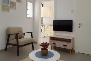 a living room with a tv and a chair and a table at Central and stylish in Rechovot