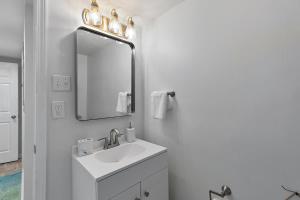 a white bathroom with a sink and a mirror at Elegant Private Basement Apartment with Full Kitchen & Living Room in Atlanta +9 photos