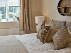 une chambre avec un lit avec des oreillers et une fenêtre dans l'établissement Willow Tree Cottage, à Foxholes