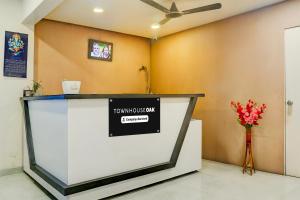 un mostrador en una habitación con un jarrón de flores en Super Townhouse Oak Viman Nagar formerly Kuber Inn, en Pune 28 fotos más
