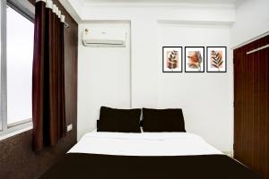 a bedroom with a black and white bed and a window at Super Hotel O Jagatpura Near JTM Mall Formerly Royan Inn in Jaipur
