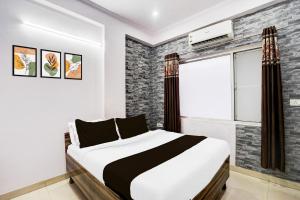 a bedroom with a bed and a window at Super Hotel O Jagatpura Near JTM Mall Formerly Royan Inn in Jaipur