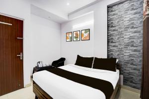 a bedroom with a large bed and a brick wall at Super Hotel O Jagatpura Near JTM Mall Formerly Royan Inn in Jaipur +22 photos