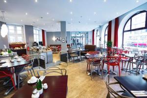 a restaurant with tables and chairs in a room at Garner Hotel Berlin - Checkpoint Charlie by IHG in Berlin