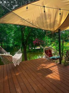two hammocks on a deck under a tent at Naturalnie i wSPAniale in Kamienica Królewska +19 photos