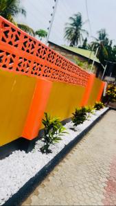バガモヨにあるMjapani Lodgeの歩道の横の塀と黄色の塀