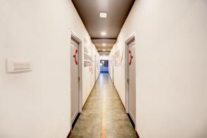 a hallway of a hospital with white walls and a long corridor at Super Hotel O Katol Road Friends Colony in Nagpur