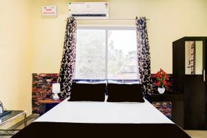 a bedroom with a bed and a window with curtains at Collection O Ganeshguri Nayanpur Formerly Rainbow Residency in Guwahati