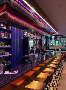 a bar in a restaurant with wooden tables and chairs at Neptuna Kata Beach in Kata Beach